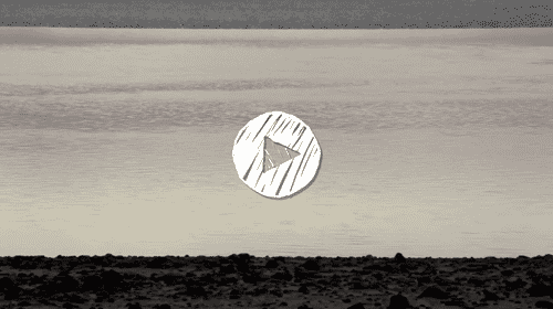 Calm body of water with gentle ripples and a rocky shoreline under a cloudy sky.